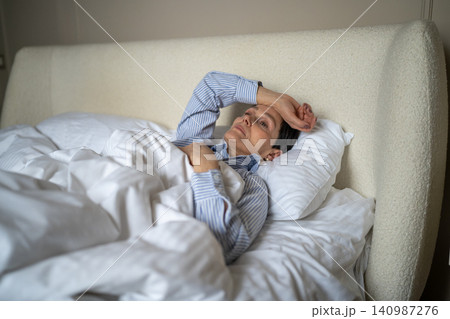 Unhappy thoughtful senior woman lying in bed in morning at home with lost exhausted expression. Unhappy thoughtful senior woman lying in bed in morning at home with lost exhausted expression. 140987276