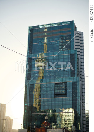 Reflective Tower Shows Crane And City Skyline 140987419