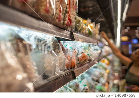 Customer taking package from fridge shelves filled with fresh food products at store in Thailand Customer taking package from fridge shelves filled with fresh food products at store in Thailand 140987659