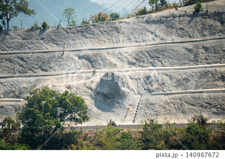 Cliff beside traffic road with working process of geological works for landslide prevention. Cliff beside traffic road with working process of geological works for landslide prevention. 140987672