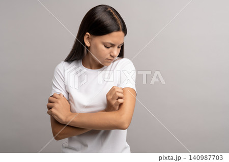 Teen girl having dermatitis, allergic reaction, hormonal problems, scratching itching painful skin 140987703