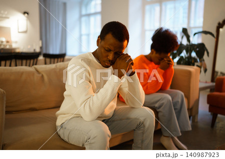 Family conflict. Unhappy african couple sit separate on couch upset thinking of breakup or divorce Family conflict. Unhappy african couple sit separate on couch upset thinking of breakup or divorce 140987923