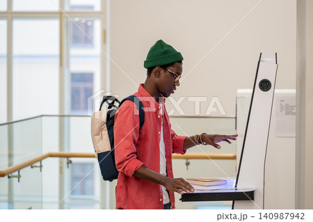 Progressive young man using self-service electronic terminal to pay in store without salesperson 140987942