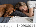 Woman with her lovely dog Vizsla sleeping together on the same pillow on the couch at home. 140988014
