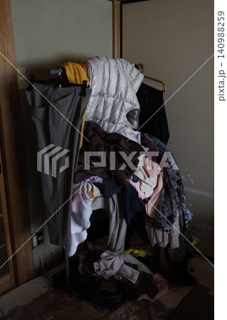 洋服が積み重なり放置されたハンガーラック。部屋の片付けと整理整頓 洋服が積み重なり放置されたハンガーラック。部屋の片付けと整理整頓 140988259