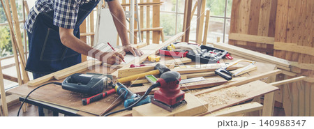 Banner DIY craftsperson asian man working wood heap carpenter objects woodwork desk. Banner Architect man hands ruler measure home improvement. Wood carpenter construction workshop with copy space Banner DIY craftsperson asian man working wood heap carpenter objects woodwork desk. Banner Architect man hands ruler measure home improvement. Wood carpenter construction workshop with copy space 140988347