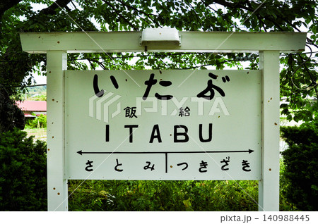 緑に囲まれた小湊鉄道・飯給駅のレトロな手書き風駅名標 140988445