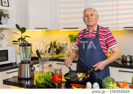 Senior old man cooking fresh vegetables on electric stovetop smelling aroma for healthy diet indoors Senior old man cooking fresh vegetables on electric stovetop smelling aroma for healthy diet indoors 140988684