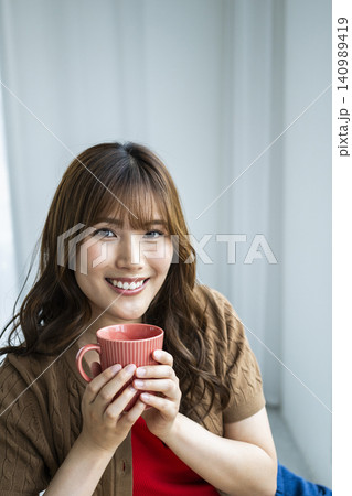 コーヒーを飲む若い女性　カメラ目線 140989419
