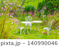 花が咲き誇る美しい庭園の白いアイアンテーブルセット 140990046