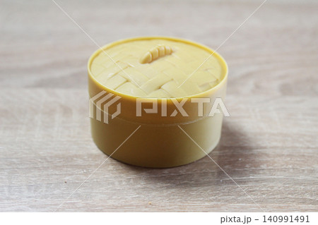 Yellow box with a squishy dumpling on a light background Yellow box with a squishy dumpling on a light background 140991491