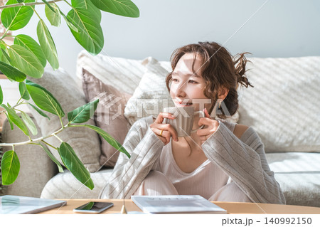 リビングでコーヒー,カフェラテを飲むおしゃれなアジア人女性 140992150