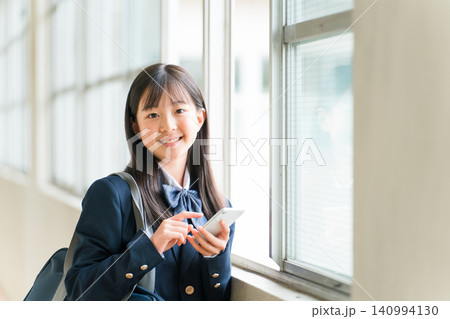 校舎の廊下でスマホを使う笑顔の高校生の女の子(フィルタリング,ネットリテラシー) 校舎の廊下でスマホを使う笑顔の高校生の女の子(フィルタリング,ネットリテラシー) 140994130