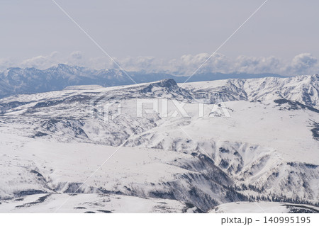 春の光に広がる雪の高原と遠い峰 春の光に広がる雪の高原と遠い峰 140995195