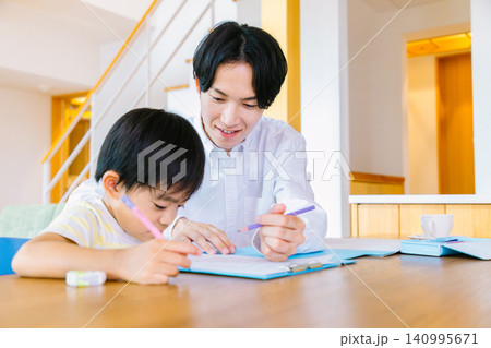 勉強を教える父親と小学生の男の子 勉強を教える父親と小学生の男の子 140995671