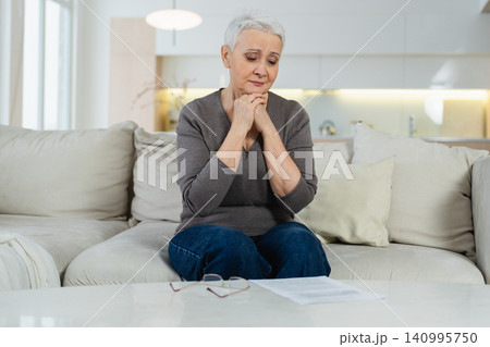 Sad tired ill sick lonely disappointed older senior woman sitting at home alone. Unhappy mature grandmother experiencing grief relative death bad news. Stressed elder lady suffering from loneliness Sad tired ill sick lonely disappointed older senior woman sitting at home alone. Unhappy mature grandmother experiencing grief relative death bad news. Stressed elder lady suffering from loneliness 140995750