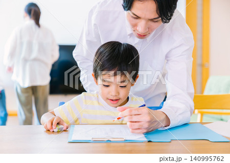 勉強をしている男の子と見守る父親 勉強をしている男の子と見守る父親 140995762