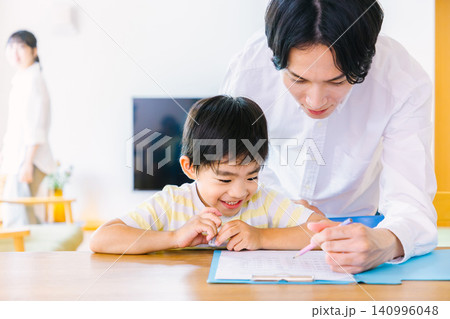 勉強をしている男の子と見守る父親 勉強をしている男の子と見守る父親 140996048