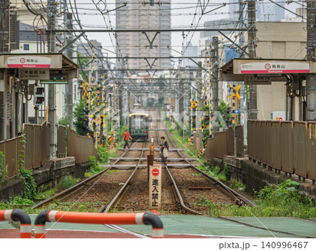 都電荒川線　飛鳥山駅付近の専用軌道と踏切を渡る歩行者 140996467