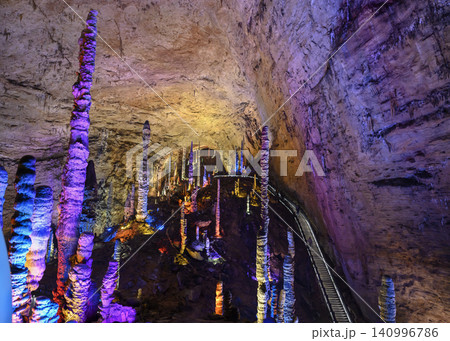 Stalactites and stalagmites colored by light in the huge Yellow Dragon Cave near Zhangjiajie, China Stalactites and stalagmites colored by light in the huge Yellow Dragon Cave near Zhangjiajie, China 140996786