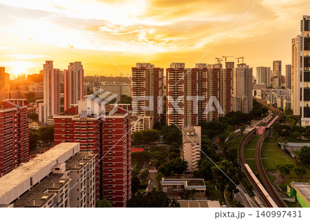 夕暮れ時の黄金色の光に包まれるシンガポールの高層公営住宅（HDB）の街並み 140997431