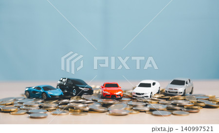 Multiple toy cars on scattered coins, representing car market pricing, vehicle finance comparison, fleet insurance, auto loan options, transportation cost, and purchase decision. Multiple toy cars on scattered coins, representing car market pricing, vehicle finance comparison, fleet insurance, auto loan options, transportation cost, and purchase decision. 140997521