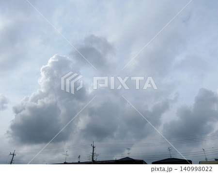 住宅街の上空に広がる大きな積乱雲、曇りがちな空 住宅街の上空に広がる大きな積乱雲、曇りがちな空 140998022
