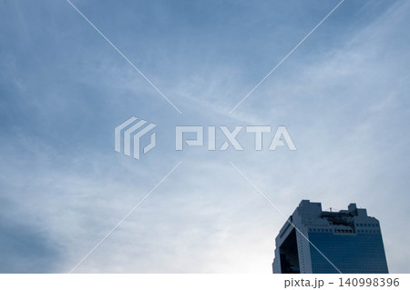 青空に広がる薄雲と高層ビル 都市の空背景素材 青空に広がる薄雲と高層ビル 都市の空背景素材 140998396