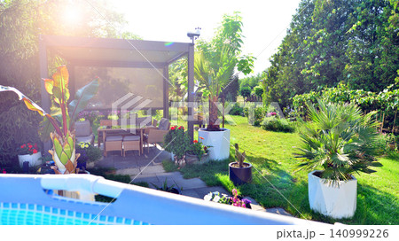 Outdoor swimming pool in a garden with lawn, plants and trees. Outdoor swimming pool in a garden with lawn, plants and trees. 140999226