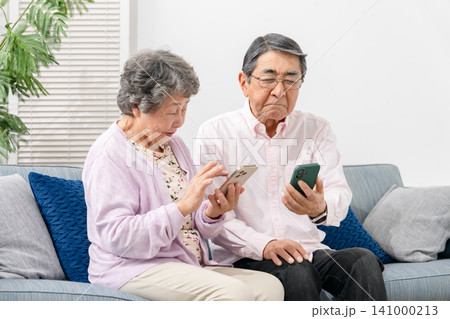 スマートフォンを持つシニア夫婦 スマートフォンを持つシニア夫婦 141000213