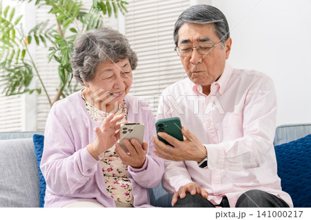 スマートフォンを持つシニア夫婦 スマートフォンを持つシニア夫婦 141000217