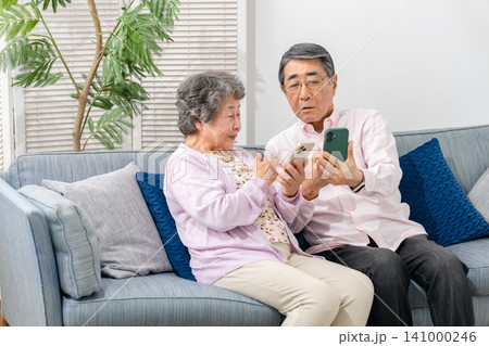 スマートフォンを持つシニア夫婦 スマートフォンを持つシニア夫婦 141000246