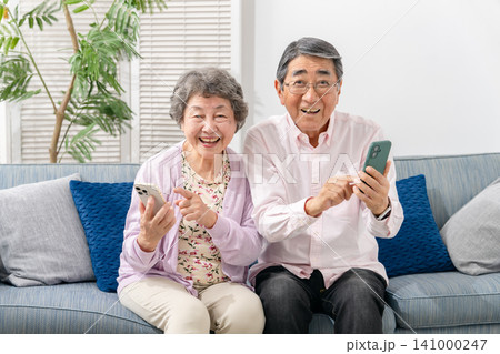 スマートフォンを持つシニア夫婦 スマートフォンを持つシニア夫婦 141000247