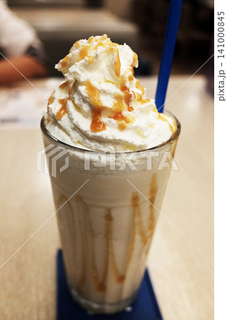 A clear glass of Iced blended latte with whipped cream, drizzled with caramel A clear glass of Iced blended latte with whipped cream, drizzled with caramel 141000845