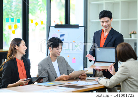 Young Asian Business Team Collaborating in Office Meeting with Laptop and Whiteboard Presentation 141001722
