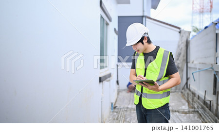 Young Asian Construction Inspector Engineer Using Digital Tablet on Building Site Wearing Safety Vest and Hardhat Young Asian Construction Inspector Engineer Using Digital Tablet on Building Site Wearing Safety Vest and Hardhat 141001765