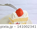 ショートケーキの真っ赤ないちごにフォークを刺すところ 141002341