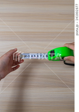 メジャーを伸ばして長さを測定する手元 メジャーを伸ばして長さを測定する手元 141002877