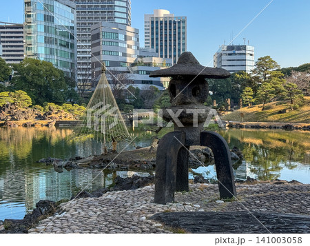 都会のビル群を背に佇む日本庭園の石灯籠と雪吊りのある風景 141003058