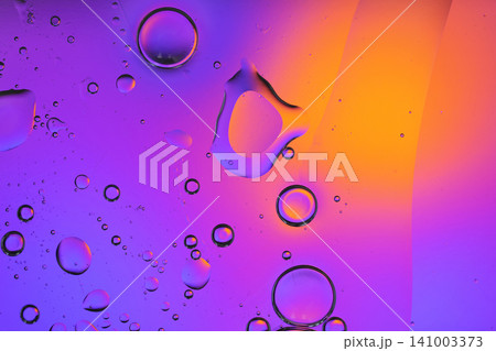 Oil and water creating vibrant purple and orange abstract bubbles Oil and water creating vibrant purple and orange abstract bubbles 141003373