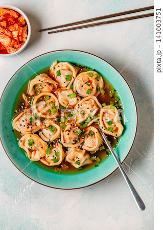 Dumplings served in a bowl with broth and green onions. Dumplings served in a bowl with broth and green onions. 141003751