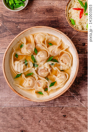 Warm bowl of wonton soup served with green onions. Warm bowl of wonton soup served with green onions. 141003803