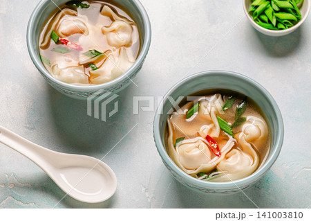 Warm bowl of wonton soup served with green onions. Warm bowl of wonton soup served with green onions. 141003810