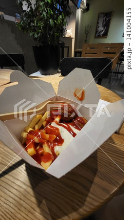 Tasty fast food nuggets and fries in a box on a wooden table, takeaway snack lifestyle, street food meal. falafel vegetarian Tasty fast food nuggets and fries in a box on a wooden table, takeaway snack lifestyle, street food meal. falafel vegetarian 141004155