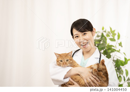 チャトラ猫を抱く女性医師 141004450