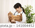 チャトラ猫の診察を抱く女性医師 141004452