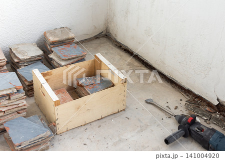 Old floor tiles are being removed from an open apartment balcony Old floor tiles are being removed from an open apartment balcony 141004920