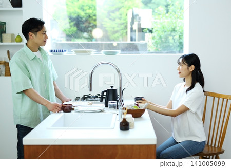 キッチンの前でくつろぐ男女のイメージ 141005099