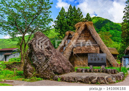 初夏の快晴 五箇山の相倉合掌造り集落に佇む国指定史跡の石碑と合掌造りの民家風景 141006188