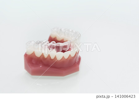 透明マウスピース矯正装置と歯の模型 白背景の製品写真 透明マウスピース矯正装置と歯の模型 白背景の製品写真 141006423